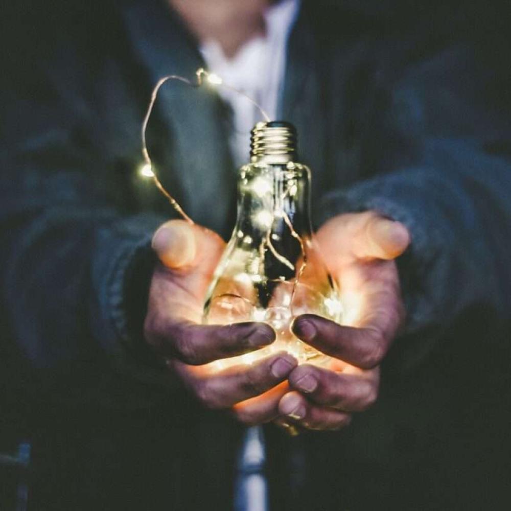 man holding a light bulb with both hands